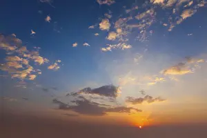 Cloudy Evening Atmosphere Impressions: Evening sunset sky with sun and dramatic clouds
