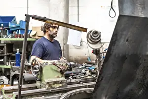 Industrial Factory Work Impressions: Factory worker operator in the numerical control sector working on a machine
