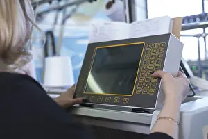 Modern Industrial Architecture Impressions: Female operator setting programme at knitting machine control panel view