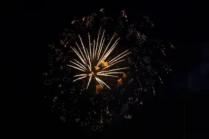 Dark Sky Fireworks Impressions: Fireworks with yellow-orange rays exploding in the night sky