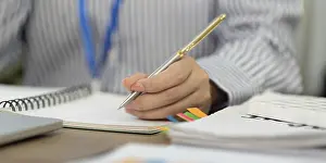 Office Communication Skills Impressions: A focused professional writes notes in a notebook