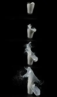 Studio Shot Tableware Impressions: Glass for Milk exploding against Black Background