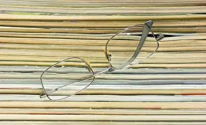 Magazine Stack Impressions: Glasses on the background of the stack of magazines