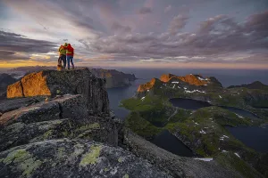 Hiking In Norway Impressions: Two hikers at the summit, sunset with dramatic clouds