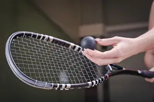 Tennis Equipment Impressions: Image of a woman's hand with a squash racket