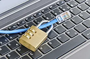 Secure Internet Connection Impressions: Internet cable and padlock on computer keyboard symbolizing data security