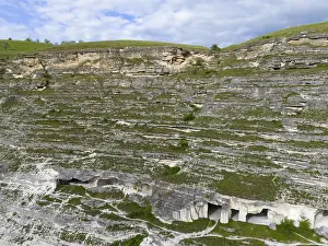 Impressions de Falaises de calcaire avec des structures de grottes visibles, sous les nuages bleus verts, vue aérienne, habitations troglodytiques, Orheiul Vechi Moldavie Impressions: Falaises de calcaire avec des structures de grottes visibles.