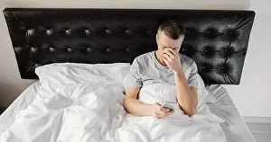 Dark Bedroom Scene Impressions: Man bed using mobile