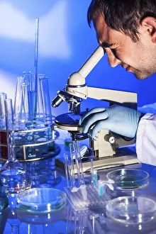 Scientist In Laboratory Impressions: Man is looking into the ocular of microscope
