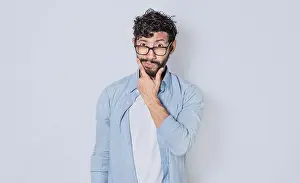 Hispanic Ethnicity Model Impressions: Man rubbing his beard with an expression of doubt