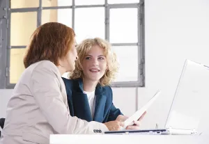 Office Work Station Setup Impressions: Manager working in an office with a trainee at the computer
