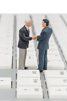 Business Communication Impressions: Two managers talking on the keyboard of a computer