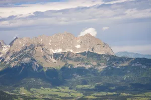 Cloudy Mountain Scenery Impressions: Massive mountain range under dramatic cloud formations and dense forest