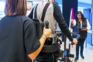 Physical Therapy Exercises Impressions: Mechanical exoskeleton. Female physiotherapy medical assistant helping disabled person with robotic skeleton to walk