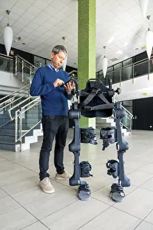 Mechanical Exoskeleton Impressions: Mechanical exoskeleton computer engineer looking at the robot with a tablet