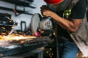 Handicraft Industry Impressions: Metalworking professional using an angle grinder in the workshop