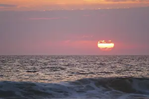 Ocean Sunset Impressions: Ocean waves on sunset with setting sun background