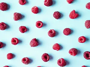 Flat Lay Fruit Photography Impressions: Pattern of ripe red raspberry on blue background