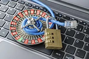 Secure Internet Connection Impressions: Roulette wheel, padlock and internet cable lying on computer keyboard symbolizing data encryption