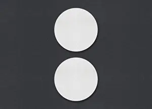 Plain Gray Background Image Impressions: Two round white sheets vertically aligned on a gray background