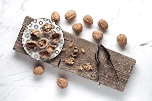 Wooden Board Arrangement Impressions: A rustic setup features whole and cracked walnuts on a patterned plate
