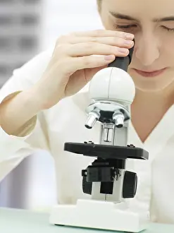 Laboratory Equipment Impressions: Scientist looking through a microscope