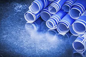 Close Up Construction Plan Impressions: Stack of blue engineering drawings on metallic background construction concept