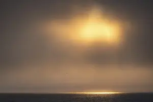 Svalbard Norway Impressions: Sun breaking through clouds, reflection on sea surface