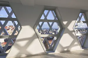 Urban Skyline View Impressions: Sunlight streams through hexagonal windows