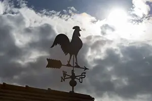 Dramatic Cloud Formations Europe Impressions: Sunlit weather vane in front of dramatic cloud formations