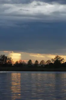 Northern German Water Scenery Impressions: Sunset over the river with dramatic clouds
