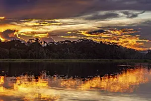 Cloudy Evening Sky Photography Impressions: Sunset over a river with dramatic sky and intense reflections