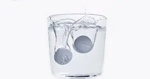Full Body Length Tablet Drop Impressions: Tablets Falling and Dissolving into a Glass of Water against White Background