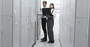 Healthcare Technology Impressions: Technicians using laptop while analyzing server in server room