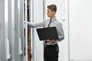 Healthcare Technology Impressions: Technicians using laptop while analyzing server in server room