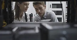 Healthcare Technology Impressions: Technicians using laptop while analyzing server in server room