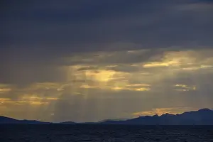 Backlit Coastal Photo Impressions: Thunderclouds at sunset on the beach