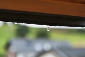 Rainy Summer Impressions: Tiny raindrop hangs on window frame