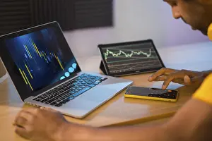 One Person Working On Pc Impressions: Trader using computer and electronic devices to work in remote from home