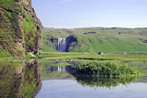 Icelands Natural Wonders Impressions: Vertically falling waterfall reflected in the water