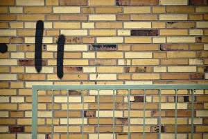Old Building Architecture Impressions: A wall made of old clinker bricks with an angular railing in front of it
