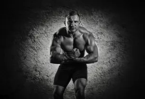 Young Man Posing Impressions: The weightlifter is posing in front of the camera