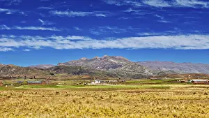 Bolivian Highland Scenery Impressions: Wide fields in front of a mountain range under a cloudy sky