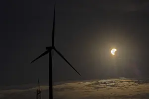 Cloudy Sky With Wind Turbines Impressions: Wind power plant, clouds, partial solar eclipse
