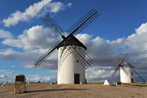 Windmill Spain Impressions: Windmill in a rural setting under a blue sky with dramatic clouds