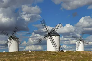 Windmills In Spain Impressions: Three windmills in front of a dramatic sky with imposing clouds