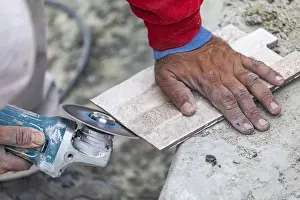 One Person Construction Team Impressions: Worker grinding corner tile for fitting