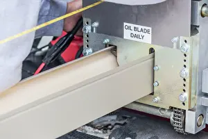 Rain Gutter Installation Impressions: Worker Measuring Rain Gutter Processing Through Seamless Shaping Machine