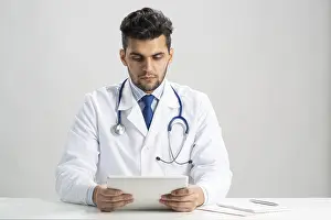 Healthcare Professional With Stethoscope Impressions: Young arab internist using tablet computer