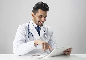 Medical Diagnosis Impressions: Young smiling internist using tablet computer
